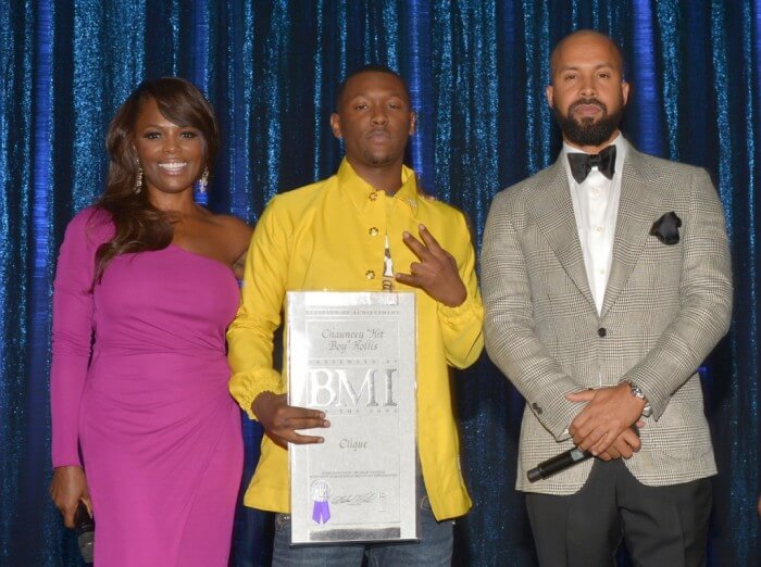 ><figcaption>BMI Vice President of Writer/Publisher Relations Catherine Brewton (L) and host Kenny Burns (R) present recording artist Chauncey “Hit-Boy” Hollis (C) with a BMI Special Citation of Achievement recognizing ‘Great National Popularity as Measured by Broadcast Performances’ of his song ‘Clique’ at the 2014 BMI R&B/Hip-Hop Awards at the Pantages Theatre on August 22, 2014 in Hollywood, California.</figcaption></figure>
<figure class=